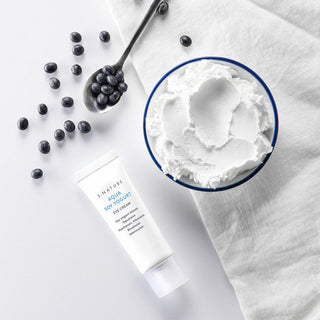 Cosmetic product with blueberries and a close-up of cream on a white background