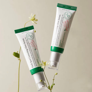 Axis-Y Dark Spot Correcting Glow Serum in a clear glass bottle, featuring a dropper applicator for anti-pigmentation skincare.