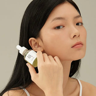 Beauty of Joseon Calming Serum with green tea extract, showcasing the serum bottle with green tea leaves in natural lighting.