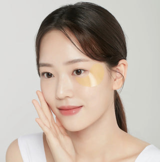 Foodaholic Hydrogel Eyepatch Gold for dark circles and under-eye spots, showing gold-colored patches on skin around the eyes.