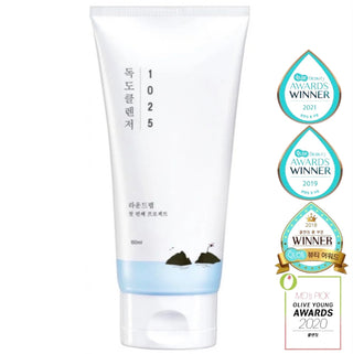Round Lab 1025 Dokdo Cleansing Foam in a white bottle with a pump, showing the gentle foam texture for deep facial cleansing.